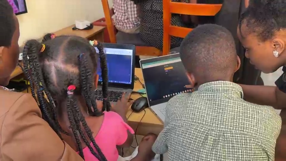 Three children and a mentor learning on laptops